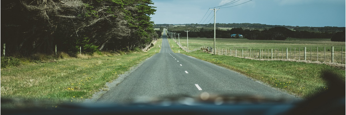 two people in the car smiling and driving