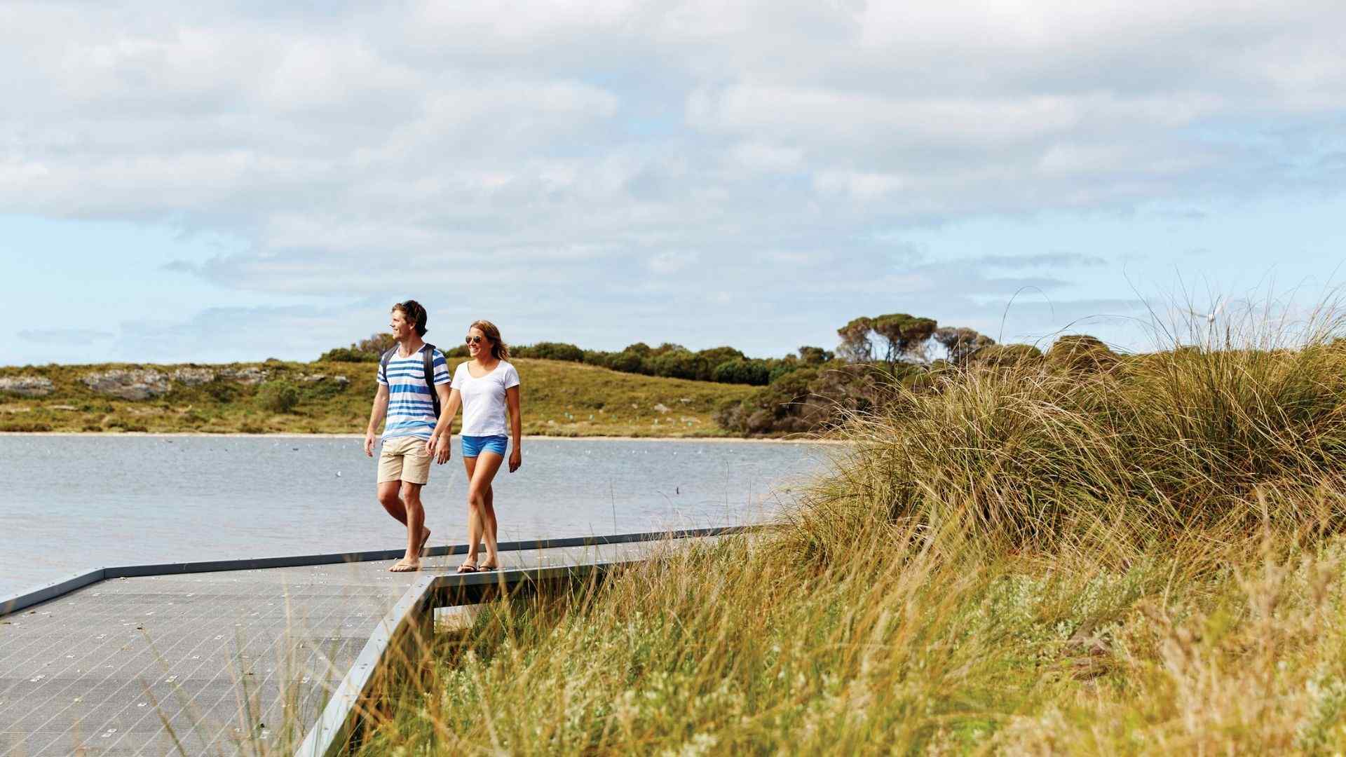 people walking on path next to beach at rottnest island 